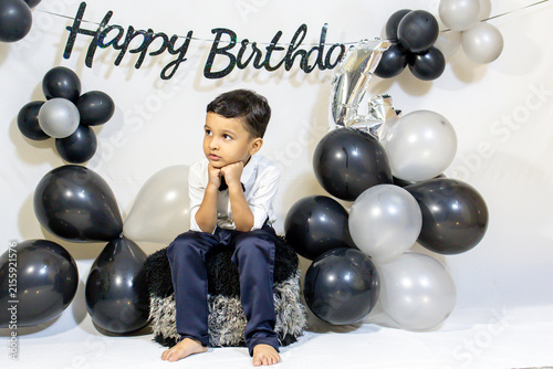 Little Boy In Formal Wear in serious mood Posing At Indoor Birthday Celebration