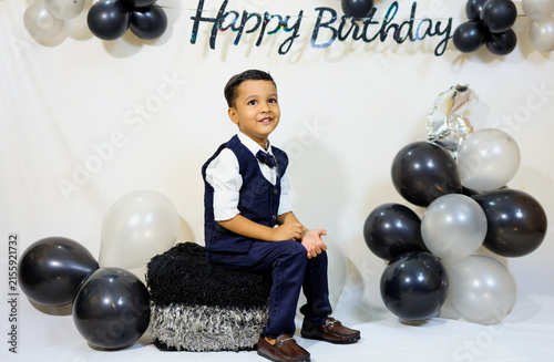 Little Boy in Formal Shirt and Bow Tie posing for photoshoot Celebrating His fourth Birthday Indoors