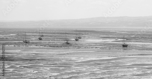Boats moored on beach at low tide, Thurstaton, The Wirral, UK