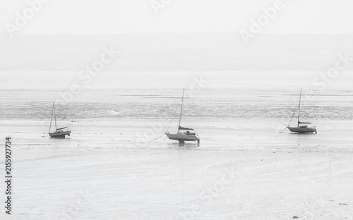 Boats moored on beach at low tide, Thurstaton, The Wirral, UK