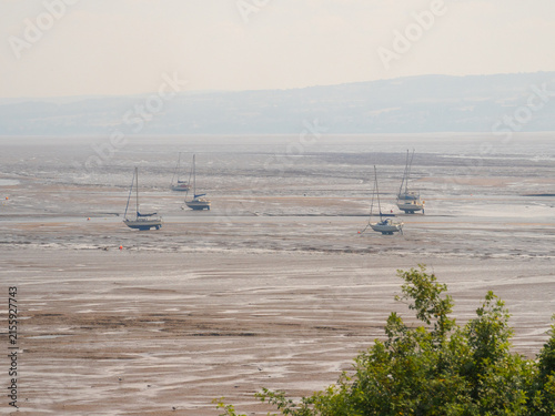 Boats moored on beach at low tide, Thurstaton, The Wirral, UK