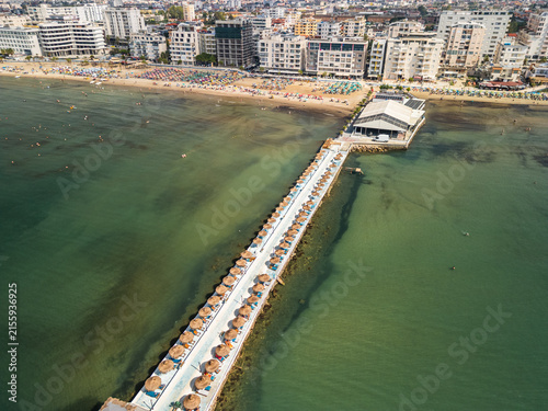Konstfotografi Albania, Durres 07 09 2025: Wide drone photo showing the pathway over the sea connecting Durres beach to Hawaii Beach Club, with resort hotels and swimmers in the background