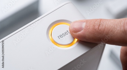 Fototapeta Hand pressing reset button on device panel