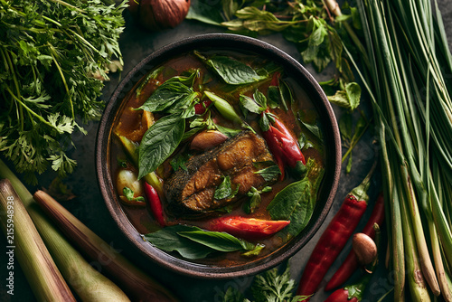 A vibrant bowl of aromatic soup with fresh herbs and colorful vegetables.