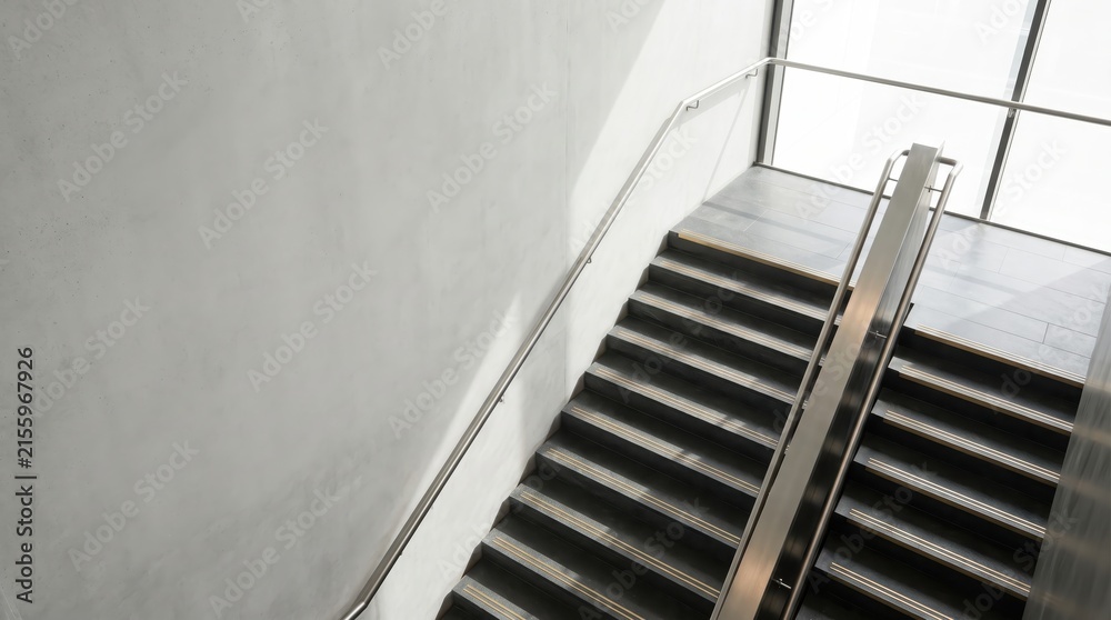Fototapeta premium Well-lit inclusive staircase uses handrails and tactile warnings on black steps for safety