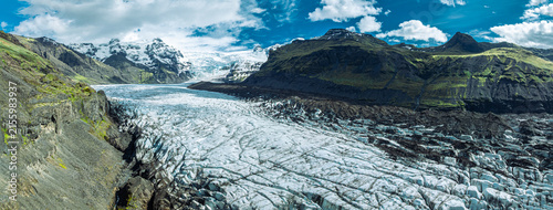 Obraz na plátně Sharp blue ice formations rise above the glacier lagoon at Skaftafellsjökull in Vatnajökull National Park, surrounded by rugged mountains and Iceland's spectacular glacial landscape