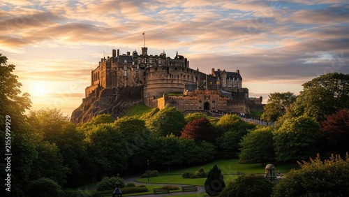 Edinburgh Castle at golden hour sunset over green parkland.