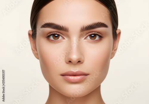 Beautiful young woman with flawless skin and perfect groomed eyebrows