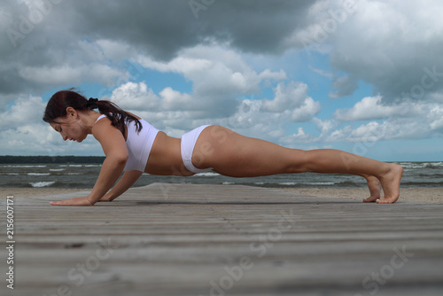 Woman Doing Push-Ups on Wooden Pier by Sea