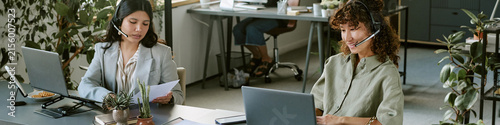 Header of diverse young adult female colleagues wearing headsets working in call center using laptops. Image suitable for customer service, telemarketing, and corporate communication marketing
