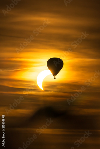 Ein Heißluftballon vor einer partiellen Sonnenfinsternis