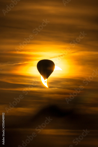 Ein Heißluftballon vor einer partiellen Sonnenfinsternis