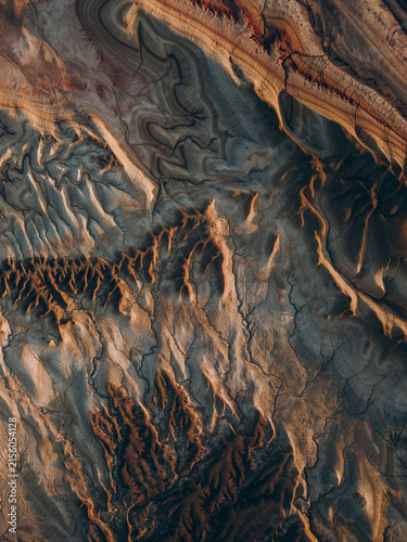 Obraz na plátně Deep carved ridges and valleys in earthy mineral tones form an abstract landscape shaped by erosion, ideal for geology, topography, earth science and modern creative backgrounds