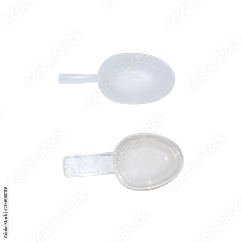 Two clear plastic measuring spoons for precise ingredient portions with studio lighting