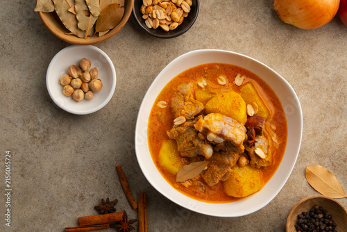 Massaman Curry with baby pork ribs (pork cartilage).Cooked pork meat and potatoes groundnut with massaman curry paste in coconut milk on white bowl.asian food.Top view.