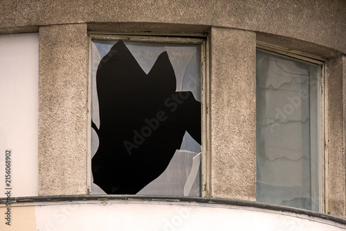 Window on building exterior with broken glass after public disorders 