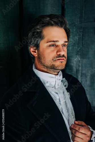 19th century European dark-haired man in tailcoat and white shirt, nobleman portrait, black background.