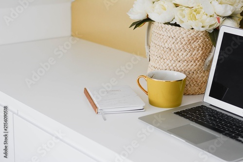 Принти на полотні Cozy home office desk setup with laptop and flower bouquet workspace notebook in