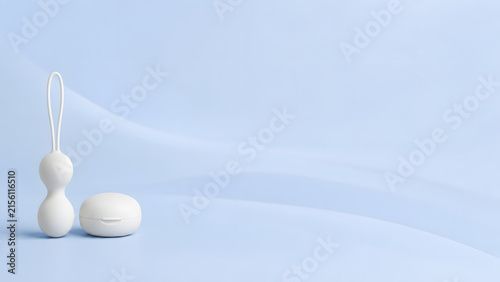 Pelvic floor exerciser weights for Kegel training arranged on a minimal light blue background with clean copy space.