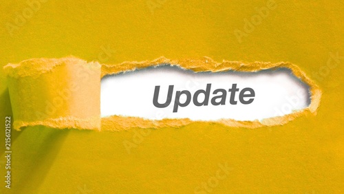 Torn yellow paper revealing word update underneath concept of news