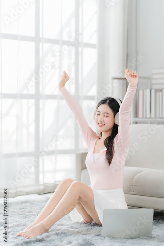 Foto Joyful Serenity: A young woman with a radiant smile listens to music with headphones, her arms raised in a gesture of pure happiness and relaxation