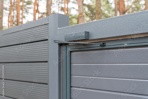 Obraz na plátně Outdoor hydraulic door closer on gray metal gate, close up