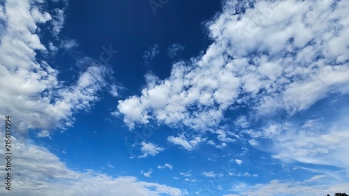 Obraz na plátně Clear blue sky with scattered light white clouds, natural background