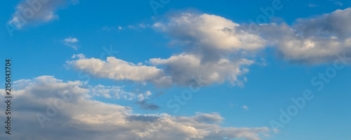 Photography Scattered white clouds lit by sun on deep blue evening sky