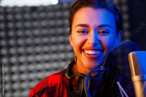 Close-up portrait of a young woman pop singer looking at camera and smiling