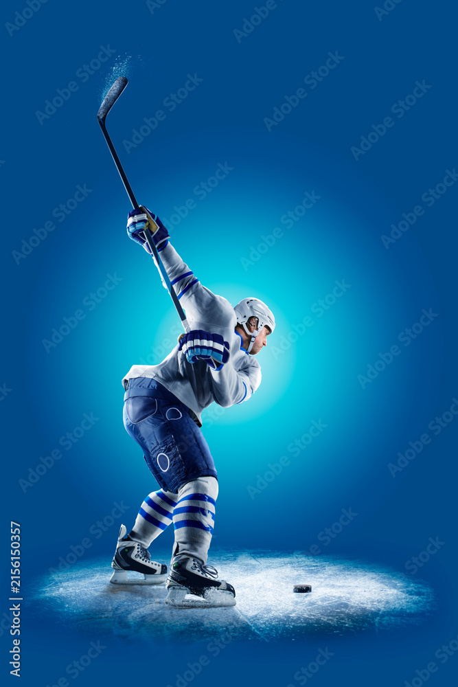 Fototapeta premium Hockey. Professional hockey player isolated on blue background. Hockey player in action. Hockey concept. Sport
