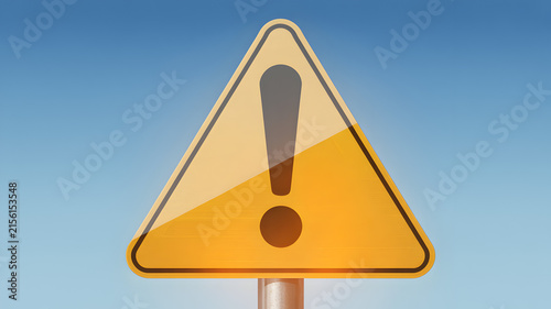 Warning sign with exclamation mark in bright daylight against blue sky for safety information.