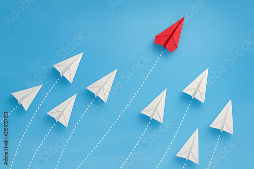 Paper Airplanes In Flight With One Red Leading The Way
