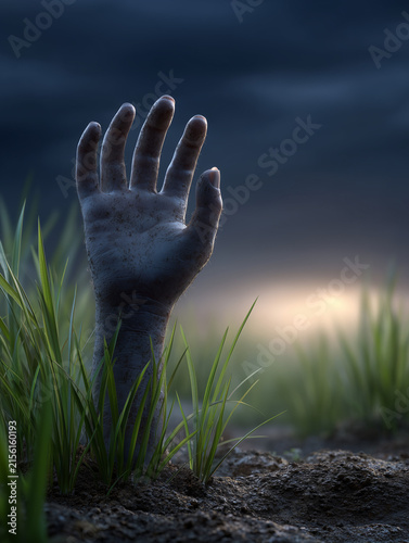 Decayed zombie hand reaching upward from cemetery grave