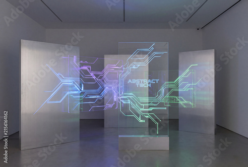 Abstract tech. An abstract technological installation in a minimalist gallery space, featuring holographic digital circuit lines projected onto clear glass and sleek metallic partition panels