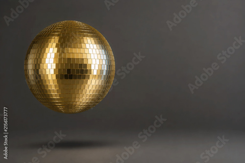 Golden Disco Ball Floating Against Dark Gray Background