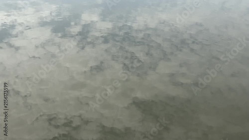 Painterly Cloud Reflections Shifting with Gentle Ripples on Calm Water Surface