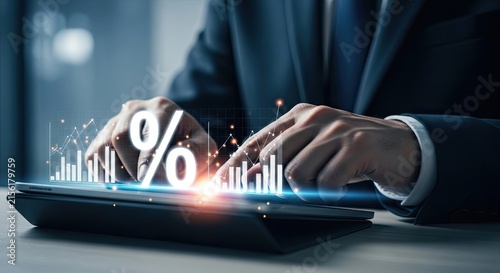 Businessman working on a laptop with holographic percentage sign and financial growth charts for investment analysis