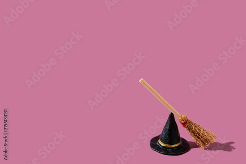 Foto Black witch hat and a broomstick on a purple background
