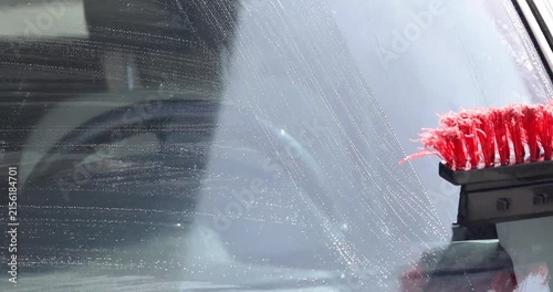 Washing the windshield with a squeegee at a gas station. Comfort and good visibility while driving on the road