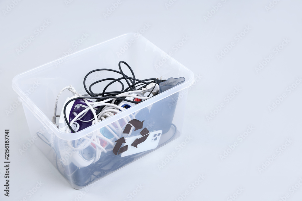 Fototapeta premium Plastic container full of broken appliances for recycling on white background, closeup. Space for text
