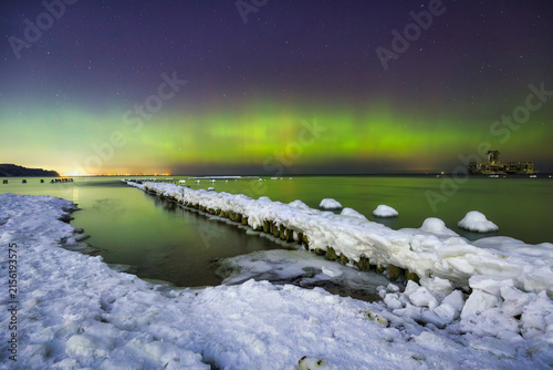 Baltic sea in Gdynia Babie Doly at winter night with northerm lights. Poland