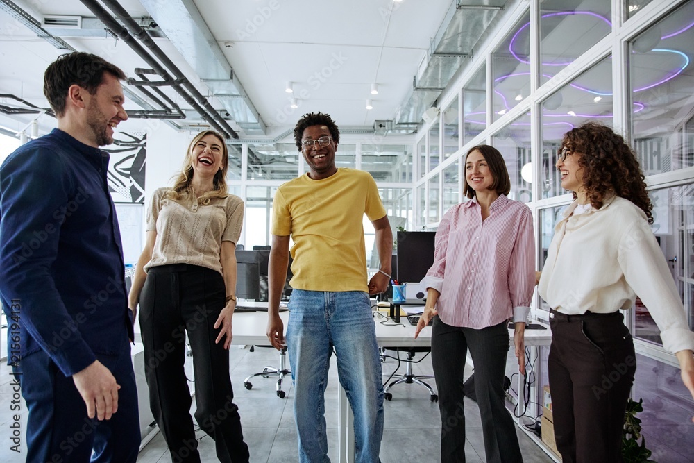 Fototapeta premium Diverse business team laughing together during a collaborative office meeting
