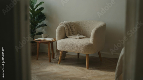 Cozy Minimalist Living Room Interior Featuring a Soft Boucle Accent Chair and Wooden Side Table for a Calm Relaxing Home Atmosphere