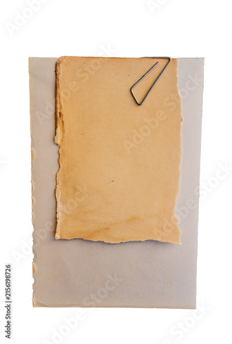 Hoja de papel antiguo con bordes rasgados y clip metálico sobre fondo blanco