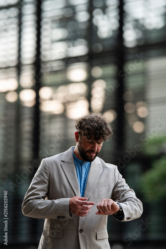 Cuadro en lienzo Professional man checking wristwatch for punctuality in city