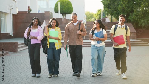 Group of diverse college students walking on campus together