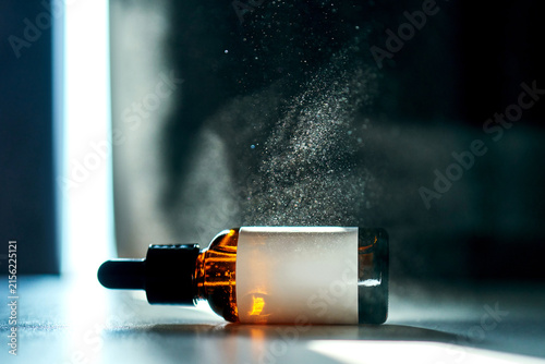 Obraz na płótnie Serum bottle laying down with glowing mist around