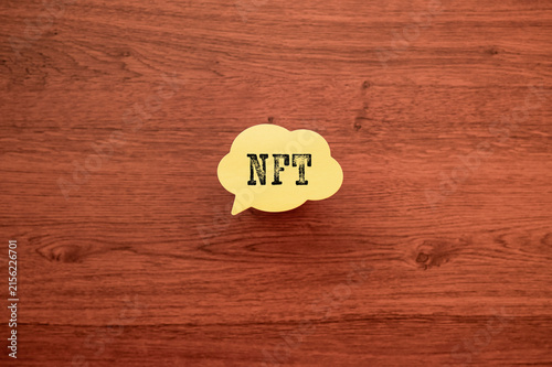 Naklejka NFT Concept Message on Speech Bubble Against Wood Desk — ideal eye-catcher for fintech and crypto blog posts