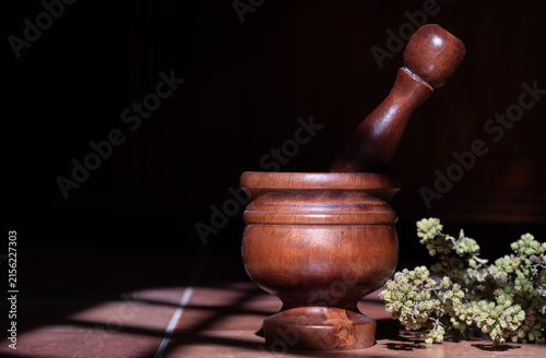 Fotografía A mortar with a wooden pestle sits on a tile floor