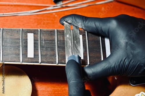 Foto A close-up photograph of a luthier wearing black protective gloves, carefully wo